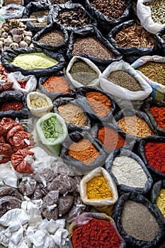 A colurful selection of spices, herbs and nuts for sale at a market stall in the Indian market in Otavalo in Ecuador.