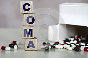 COMA word on a light background with a box of tablets