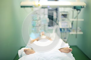 Comatose patient in ICU ward, defocused background photo