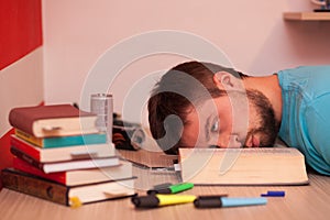 Comatose student with his head lying in the middle of a big book