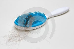 Comb with a lot of hair loss. Health problems. Alopecia. Thin and weak hair. White solid background.