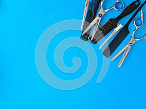 Comb scissors and accessories for hairdressers on blue background