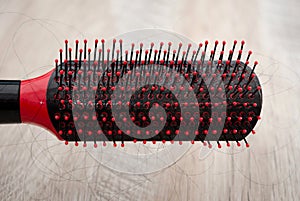 Comb with shreds of hair on a wooden background. Close-up.