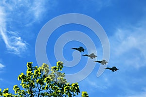 Combat aircraft fighters fly against the blue sky. Jet squadron
