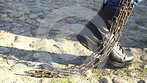 Combat boots tugging chain prison concept