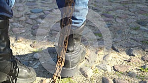 Combat boots tugging chain prison concept