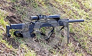 Combat rifle with sniper scope is on the ground