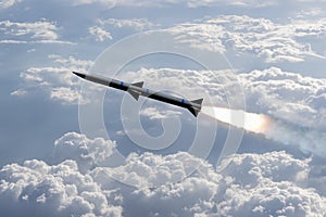 A combat rocket is flying above the clouds, smoke and fire from the rocket. Concept: missile attack, air attack, war between Russi photo