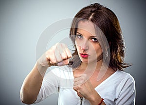 Combative young woman punching at the camera photo