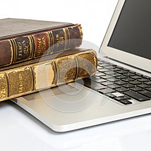 Antique Books on a Modern Laptop isolated on white background photo