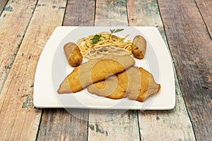 Combination dish with breaded chicken entrecote, croquettes stuffed with bÃ©chamel and Iberian ham and spaghetti