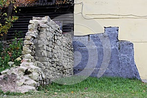 combination historic masonry in the form of a dilapidated wall and modern beije wall of house.