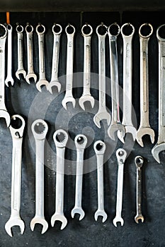 Combination wrenches set in auto repair shop. Mechanics repairing, maintaining car in garage. photo