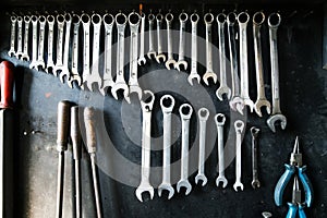 Combination wrenches set in auto repair shop. Mechanics repairing, maintaining car in garage. photo
