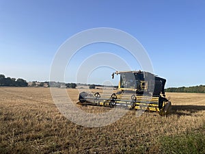 Combine Harvester agricultural equipment parked on a harvested field.