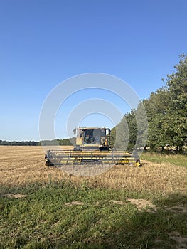 Combine Harvester agricultural equipment parked on a harvested field.