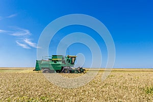 Combine harvester agriculture machine harvesting yellow ripe wheat field