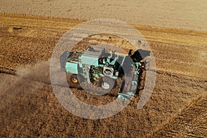 Combine harvester harvests ripe wheat aerial view. Agriculture field and farming concept