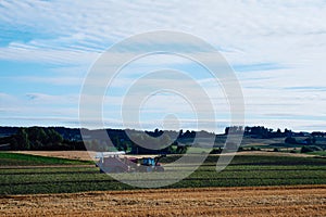 Combine harvester in the lush fields of Toten on a summer morning, Norway - an agricultural concept