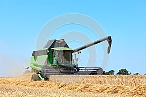 Combine harvester machine harvesting wheat on a field