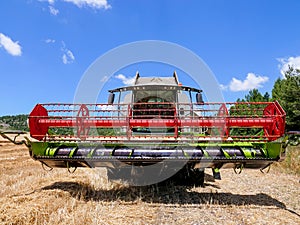 Combine harvester parked in a large Wheat field.