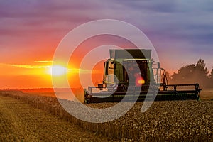 Combine harvester at sunset