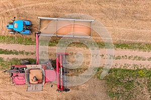 Combine harvester and a tractor working on a wheat field