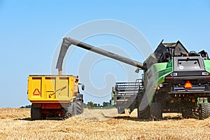 Combine harvester unloading wheat into a trailer