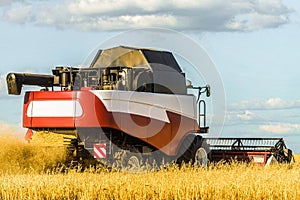 Combine harvester with ÃÂutter platform at work. Reaping machine. photo