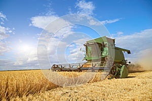 Combine harvester on a wheat field with blue sky