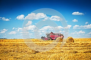Combine harvester working on field of wheat