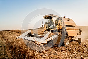 Combine harvester working the fields during sunset hour