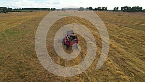 Combine harvester working in wheat field. Harvesting machine during cutting crop in a farmland. Aerial view of Combines during
