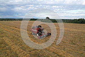 Combine harvester working in wheat field. Harvesting machine during cutting crop in farmland. Aerial view of Combines on grain