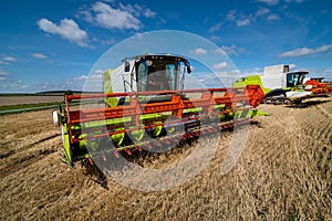 Combine harvesters row close up in wheat field, harvesting.