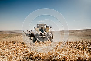 Combine harvesting the corn at sunset hours, agriculture industry