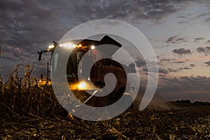 The combine harvests at night