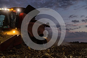 The combine harvests at night