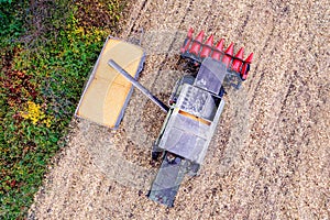 Combine loading corn grain on trailer.