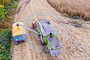 Combine loading corn grain on trailer.