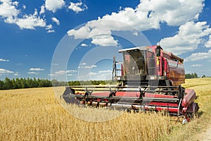 Combine machine with air-conditioned cab harvesting oats on farm field photo