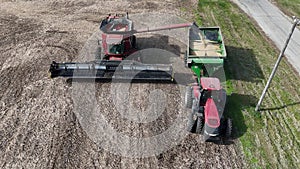 combine unloading corn into grain wagon at harvest time