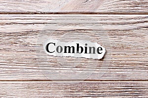 COMBINE of the word on paper. concept. Words of COMBINE on a wooden background