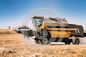 Combine working in agricultural fields. Farmer using combine harvester and collecting corn
