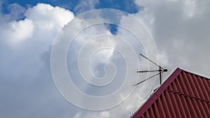 Combined TV antenna mounted on the red roof of the building.