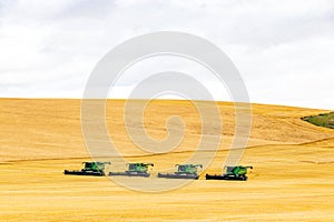 Combines lined up in a field. Wheatland County, Alberta, Canada