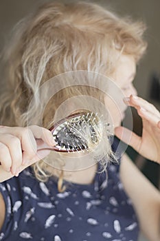 Combing with brush and pulls long hair. Daily preparation for looking nice.