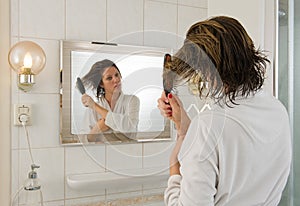 Combing hair in bathroom