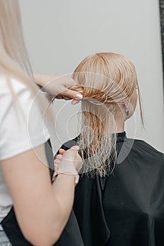 Combing the hair drying brush. Stylist drying woman hair in hairdresser salon