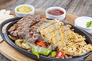 Combo Fajita; top down photo of mexican steak and chicken fajitas in iron skillet with corn tortillas